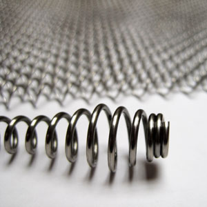 A close-up of a stainless steel pull with a stainless steel mesh screen in the background